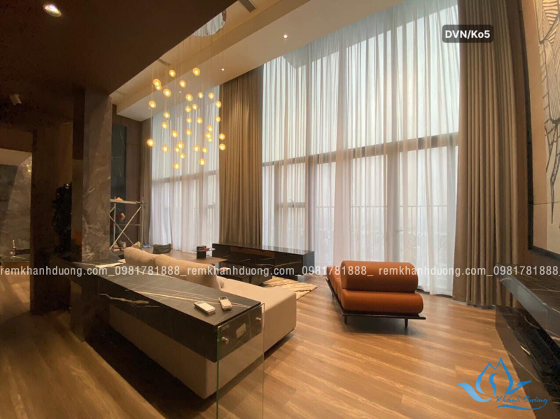 Rèm thông tầng là một xu hướng mới trong thiết kế những năm gần đây, ra đời cùng với đột phá trong xây dựng xây nhà theo kiểu kiến trúc thông tầng, nhằm manglại cho ngôi nhà có một không gian cực kì tráng lệ và sang trọng, giúp lấy nhiều ánh sáng tự nhiên vào và làm thông thoáng cho không gian sống bên trong.Rèm vải thông tầng thường được sử dụng để trang trí nội thất và tạo ra không gian thoải mái, hiện đại trong các phòng khách, phòng ngủ, hoặc văn phòng làm việc. Trong bài viết này, Rèm Khánh Đường sẽ giới thiệu đến quý khách một mẫu rèm vô cùng thu hút. Đây là mẫu rèm thông tầng được thiết kế theo phong cách thanh lịch, sang trọng dành cho phòng khách. Mẫu rèm này được chị Linh lựa chọn cho phòng khách căn biệt thự gia đình mình tại Tây Hồ, Hà Nội.